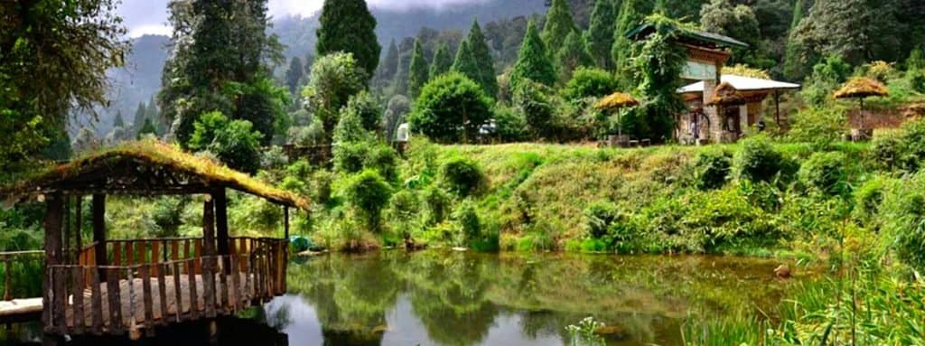 Wide view of the Lamperi park pond ringed by rocks and forest