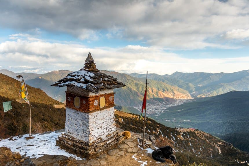 Snow-dusted chorten overlooking Thimphu valley and forested Himalayan ridges